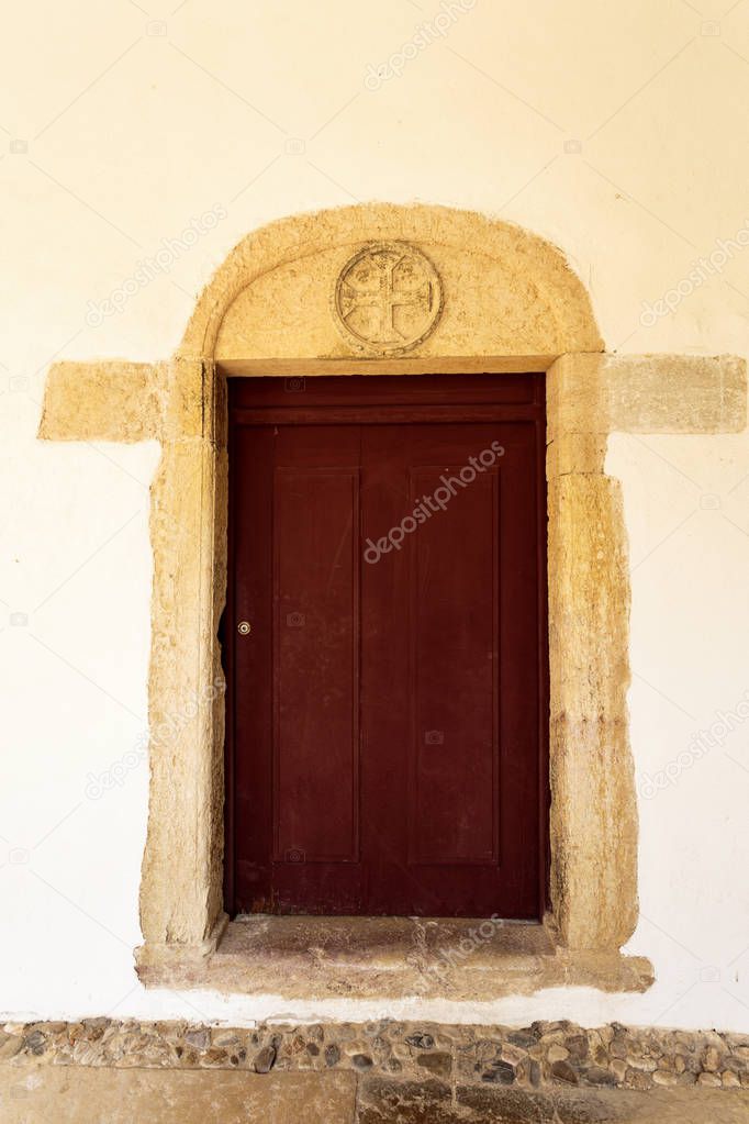 Detail of a door with the Cross of Christ in the architrave, symbol of the Order of Christ, in the Micha Cloister of the Convent of Christ, Tomar, Portugal