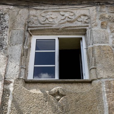 Celorico da Beira, Beira Alta, Portekiz eski bir binanın cephesinde çiçek öğeleri ve bükülmüş ip ile dekoratif bir Manuelin penceresinin görünümü