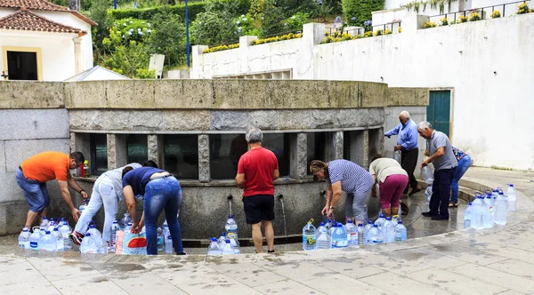2018年7月23日 在葡萄牙卢索 人们从卢索镇中心的圣约翰免费供应喷泉中收集著名的阿瓜 Luso 矿泉水 — 图库照片