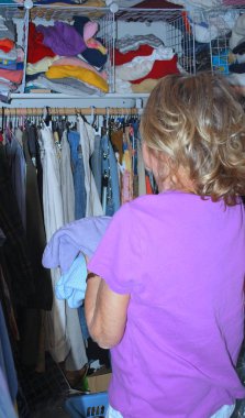 Olgun kadın kıdemli evde kalabalık dolabında bir kazak bulmaya çalışıyorum.