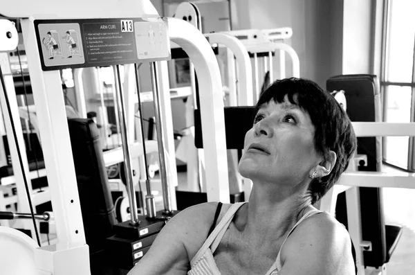 Mature Female Senior Working Out Weight Machines Healthclub — Stock Photo, Image