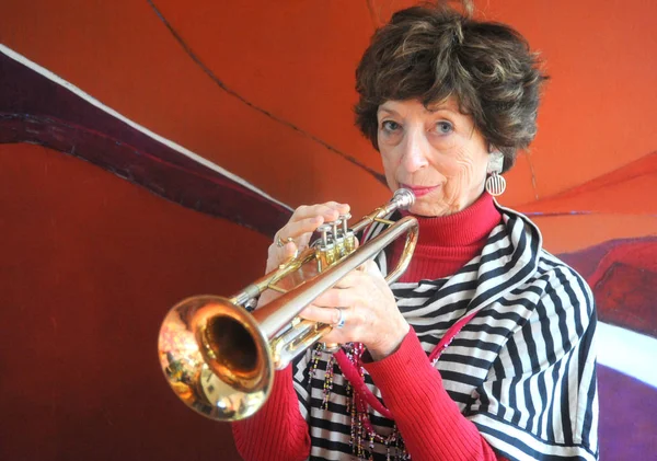 Vrouwelijke Senior Jazz Trompettist Waait Haar Hoorn Binnenshuis — Stockfoto
