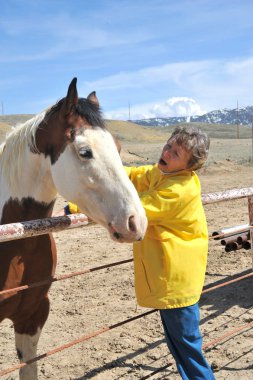 Kadın çiftlik sahibi ile onun at açık havada yapıştırma.