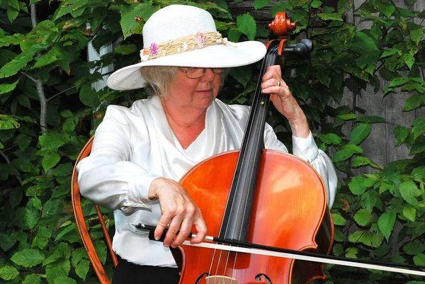 成熟的女性大四发挥她的大提琴外 — 图库照片