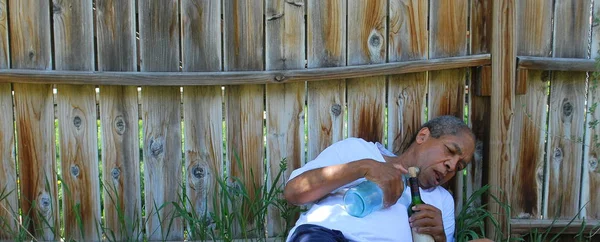 アルコールの家主が彼の裏庭で酔って渡された — ストック写真