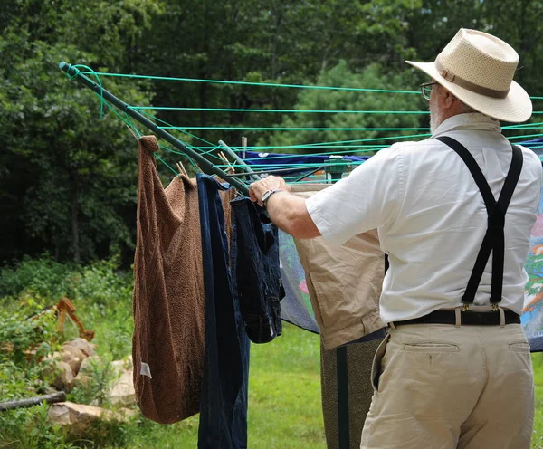 男性高级洗衣和烘干洗衣在他的后院 — 图库照片