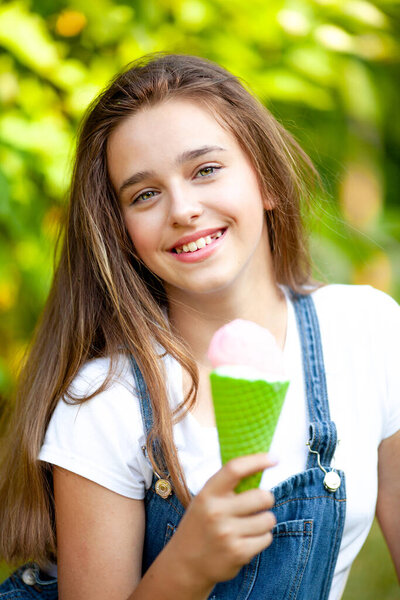 portrait of a beautiful girl teenager with a strawberry ice cream cone in her hands