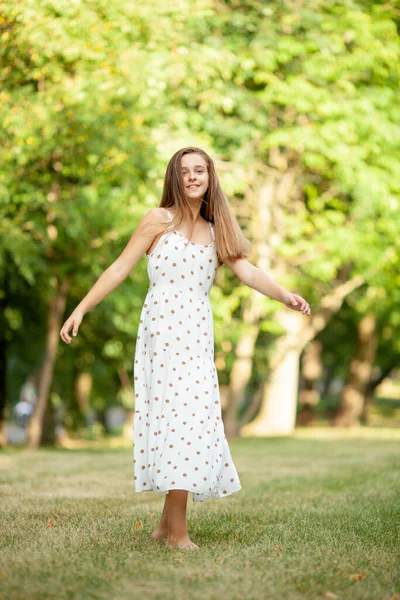 Девушка Белом Платье Горошек Крутится Парке Траве — стоковое фото