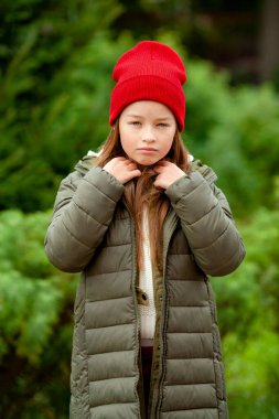 Bulanık bitki arka planında sıradan sonbahar elbiseleri giyen bir kız.