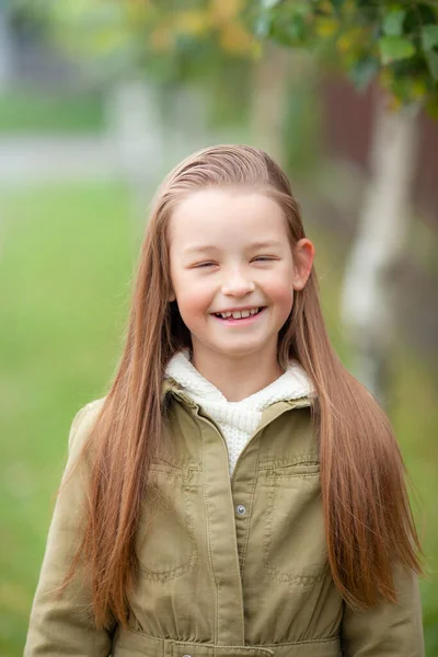 Bulanık bitki arka planında sıradan sonbahar elbiseleri giyen bir kız.