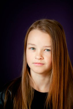 Siyah tişörtlü bir kızın koyu arkaplanda koyu bir portresi.