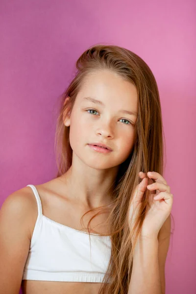 一个温柔的9岁长发女孩面对紫丁香墙的肖像 — 图库照片