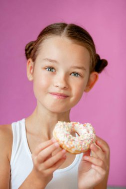 Elinde iştah açıcı jöleli donut tutan bir kız.