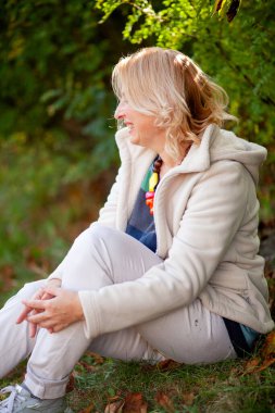 Sonbahar parkında yürüyüş yapan bir kadın.