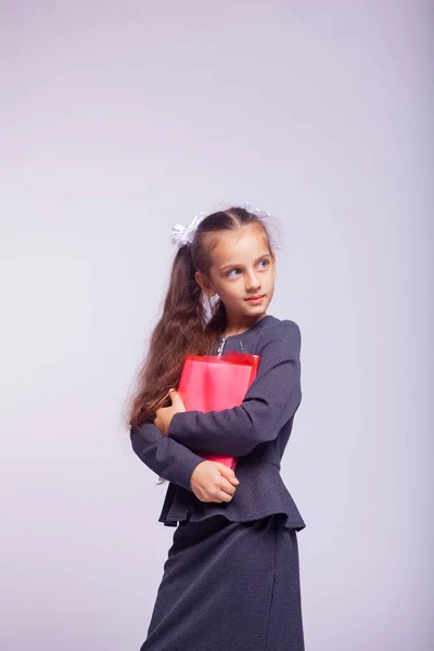 Katı Okul Kıyafetleri Içinde Açık Gri Arka Planda Bir Kızın — Stok fotoğraf