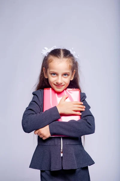 Katı Okul Kıyafetleri Içinde Açık Gri Arka Planda Bir Kızın — Stok fotoğraf