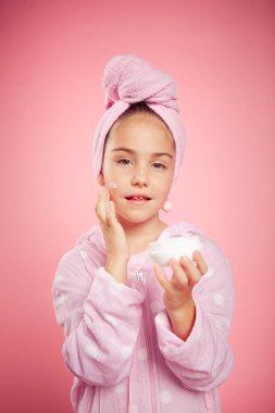 Pembe gecelikli ve kafasında havluyla bir kız.