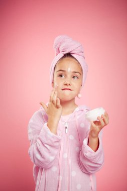 Pembe gecelikli ve kafasında havluyla bir kız.