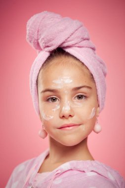 Pembe gecelikli ve kafasında havluyla bir kız.