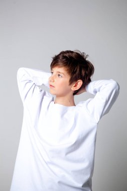 Uzun kollu beyaz tişörtlü çocuk.