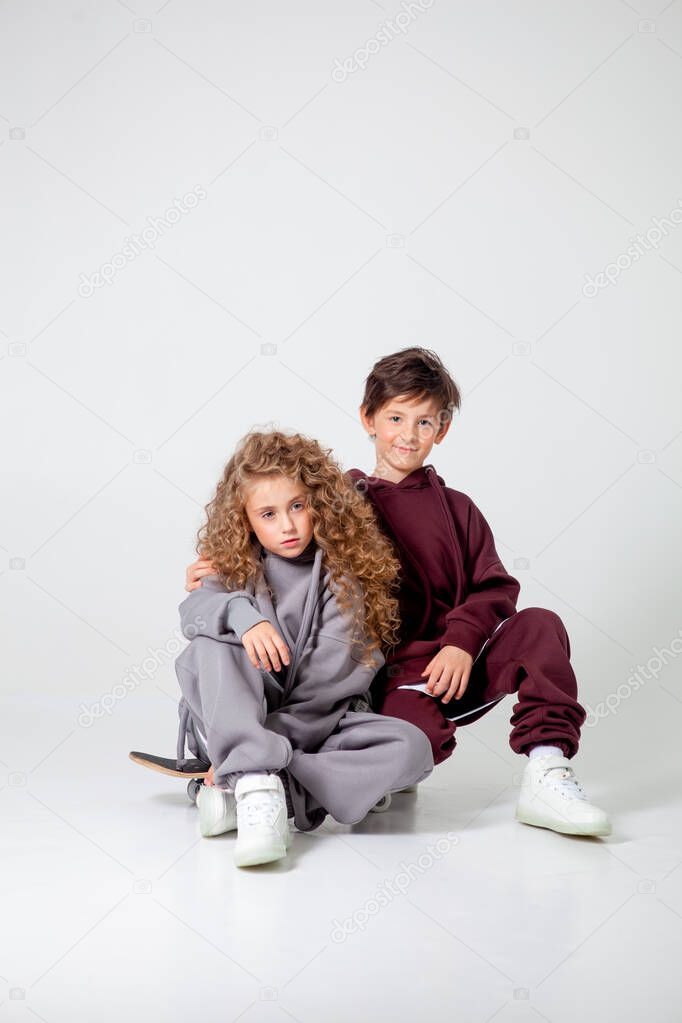 curly long-haired girl and boy in tracksuits