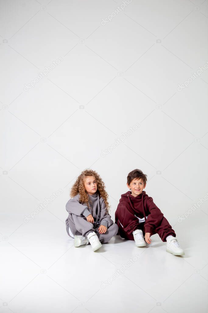 curly long-haired girl and boy in tracksuits