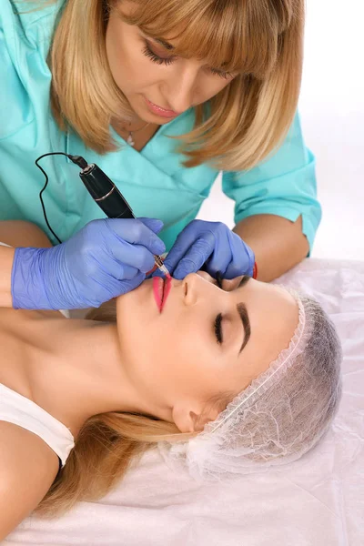 Cosmetólogo haciendo maquillaje permanente en los labios de las mujeres —  Fotos de Stock