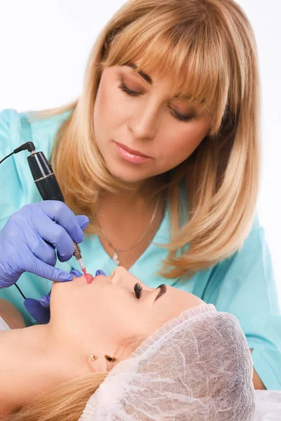Cosmetologist fazendo maquiagem permanente nos lábios das mulheres — Fotografia de Stock