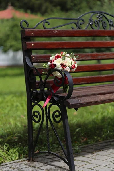 Strauß mit Rosen auf Bank im Park — Stockfoto