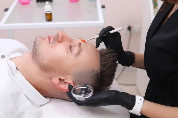 Limpiar la cara de un hombre en un salón de belleza . —  Fotos de Stock