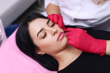 Kadının yüzünde kalıcı makyaj yapma güzellik uzmanı