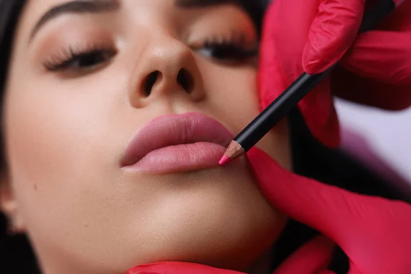 Косметолог делает постоянный макияж на женском лице — стоковое фото