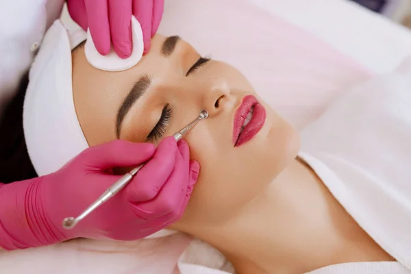 Professional cleansing of acne in a beauty salon.