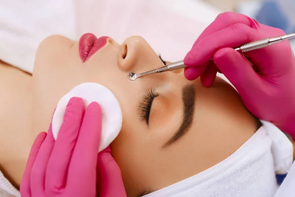 Professional cleansing of acne in a beauty salon.