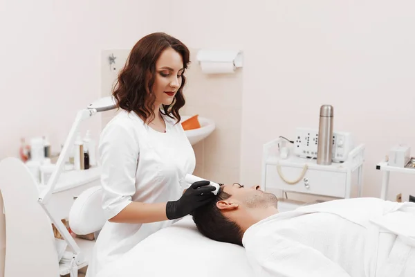 Gezicht microneedling behandeling met een meso-roller. — Stockfoto