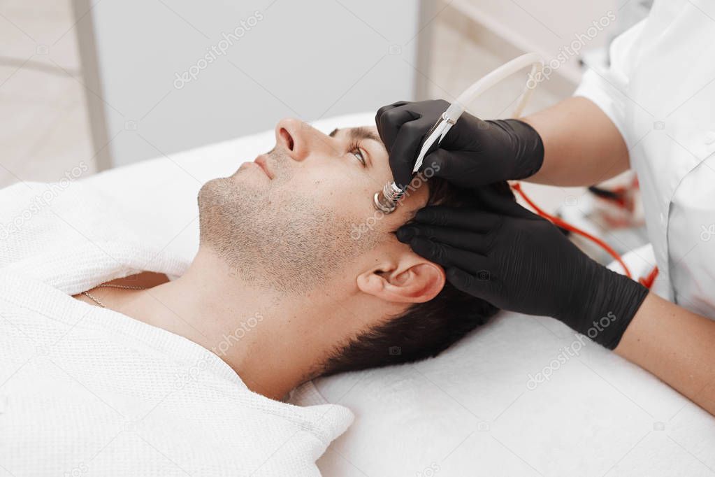 The cosmetologist makes the procedure Microdermabrasion