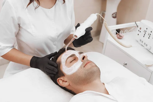 Cara de cliente clínica de beleza. Homem a fazer terapia de darsonval . — Fotografia de Stock