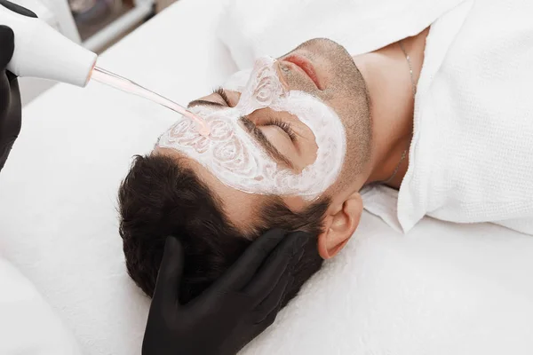 Cara de cliente clínica de beleza. Homem a fazer terapia de darsonval . — Fotografia de Stock