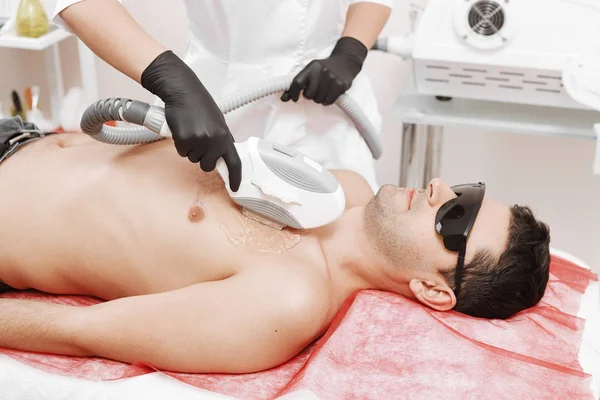 Therapeutin behandelt jungen Mann in Spa mit Laser-Epilation — Stockfoto