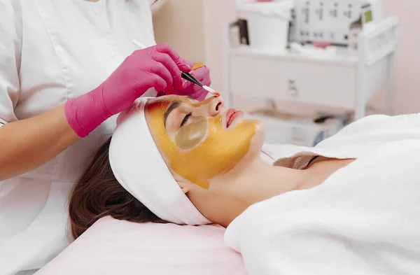 Wellness-Frau trägt Gesichtsreinigungsmaske auf. Stockbild