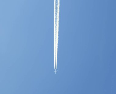Mavi gökyüzüne karşı bir uçağın izi.