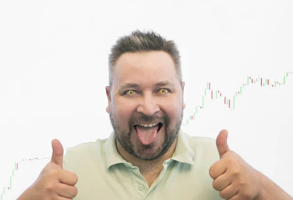 熱狂的な男の口を開いて 舌を突き出株価チャートの背景に対して親指を表示し — ストック写真