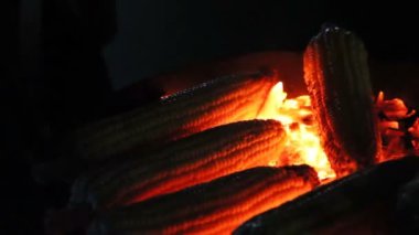 Karanlık closeup kömürlerin üzerinde kavrulmuş Mısır