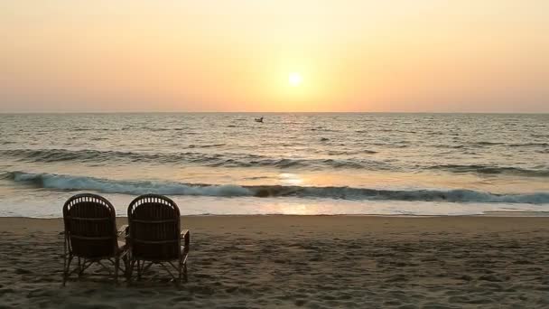 日落的时候在海岸线附近的两把椅子 — 图库视频影像