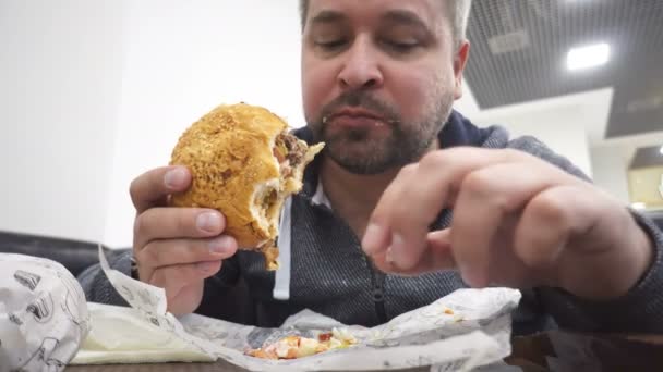 Hombre Hambriento Comiendo Hamburguesa Grande Cafetería Comida Rápida — Vídeos de Stock