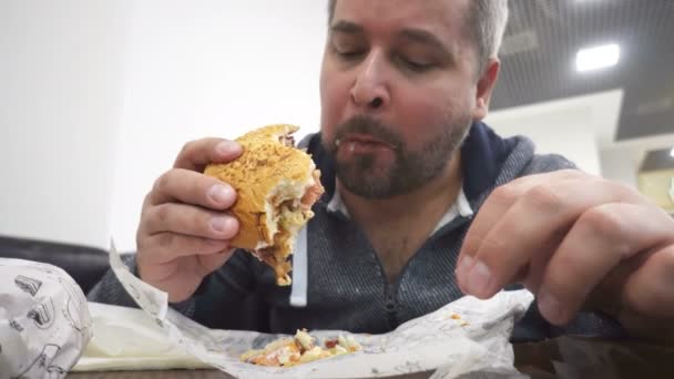Homem Faminto Comendo Hambúrguer Grande Café Fast Food — Vídeo de Stock