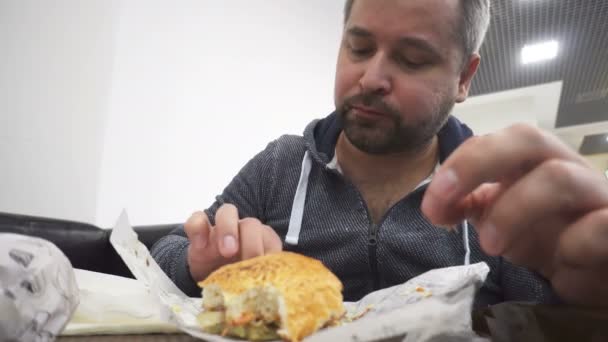 饥饿的人吃大的汉堡包快餐咖啡馆 — 图库视频影像