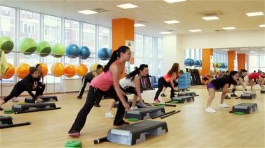 Fitness egzersizi sırasında adım panosunda güzel kadın.