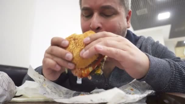 Hombre Hambriento Comiendo Hamburguesa Grande Cafetería Comida Rápida — Vídeo de stock