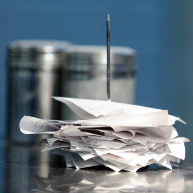 Closeup shot of note spike with receipts on it clipart